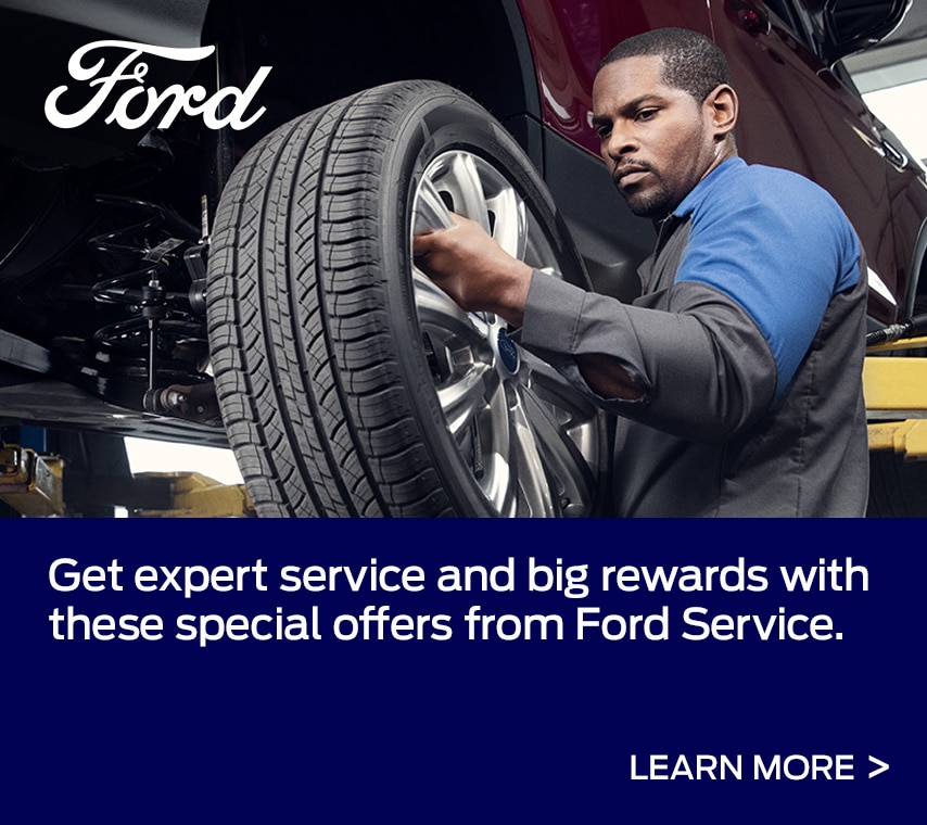 A Ford Service Technician installs a tire on a vehicle. Caption: Get expert service and big rewards with these special offers from Ford Service. See Your Offer
