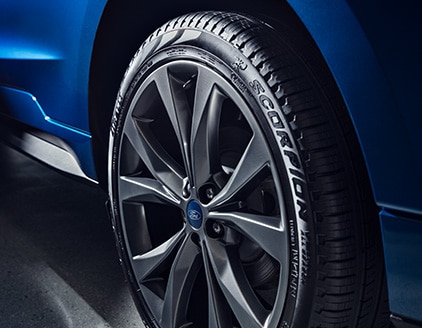  Closeup view of a tire on a blue vehicle. 