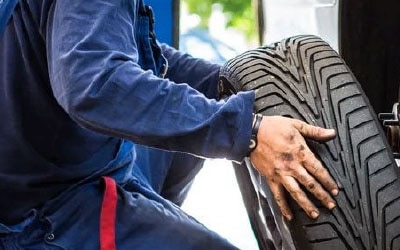 Ein Ford Service Mitarbeiter prüft einen Reifen