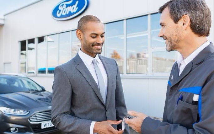 Zwei Personen bei einem Ford Händler