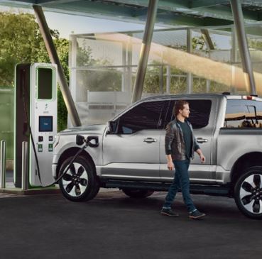 A person is standing next to a Ford F-150 Lightning