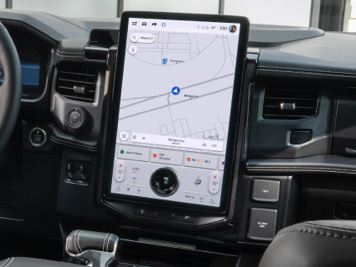 A tablet is shown mounted to the dash of a vehicle