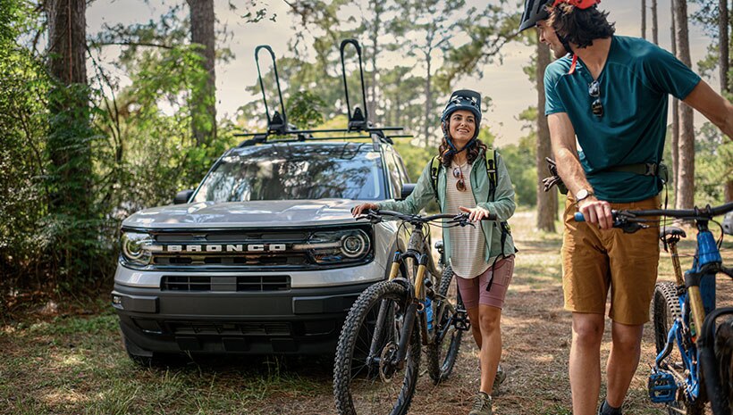 Bronco and bicycle riders in the woods