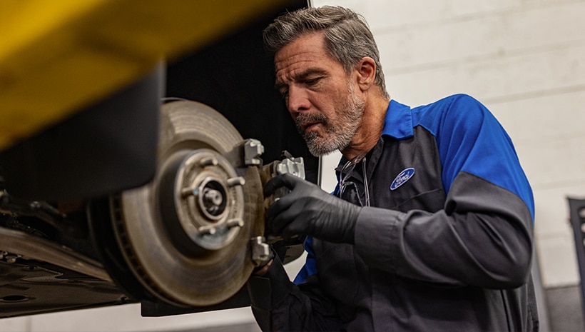 Technician working on brakes in a service bay