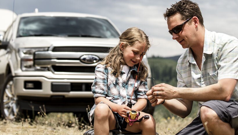 Family with fishing gear and truck
