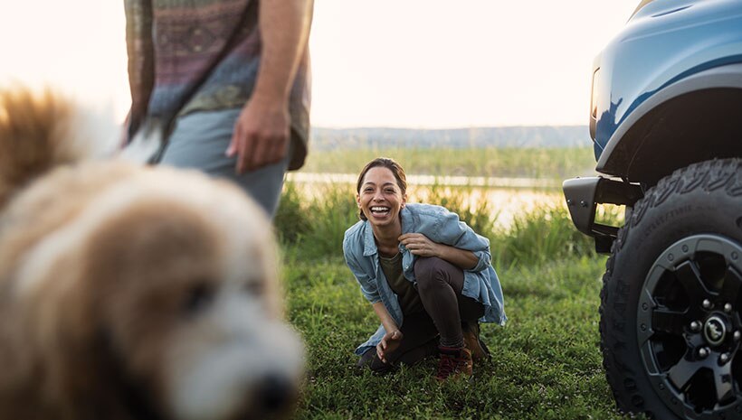 Vehículo cerca de una familia y perro