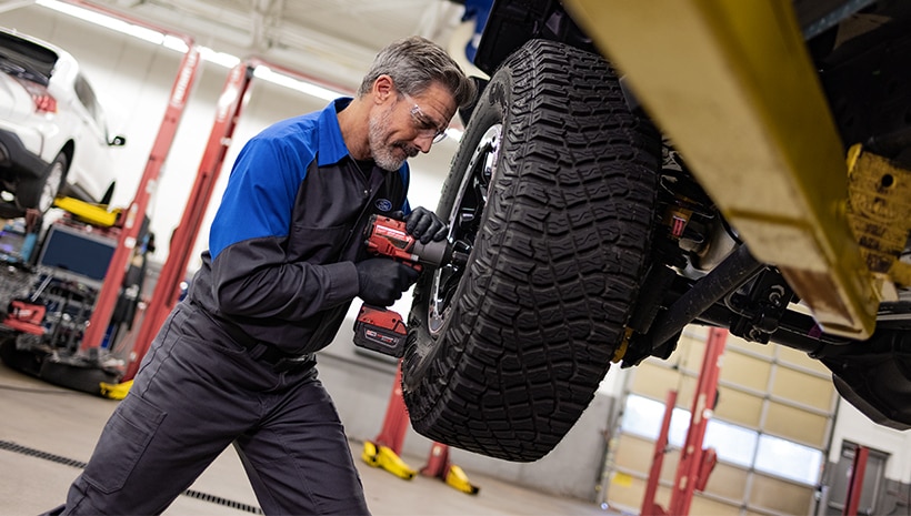Service technician with TIre in service bay