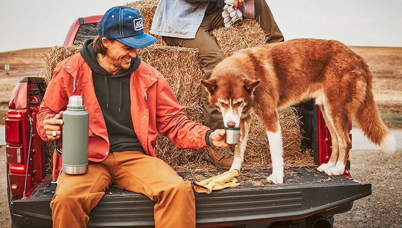 Hombre con perro en la plataforma de una camioneta