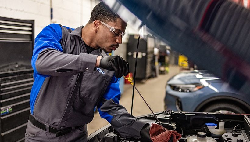Technician working on vehicle in service bay