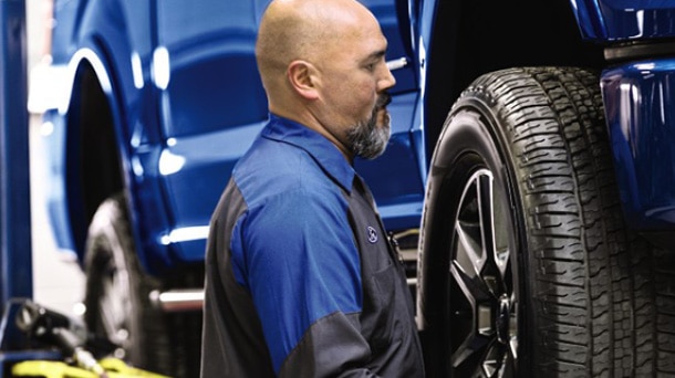 Ford service technician fitting a tire to a Ford vehicle