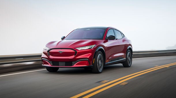 Una Ford Mustang Mach-E roja circulando por una calle.