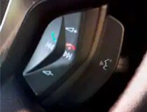 The button on the steering wheel that the driver can press for voice commands.