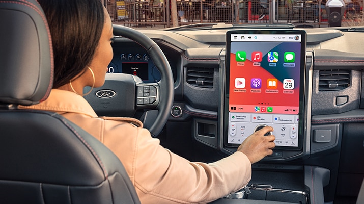 A person is shown accessing the SYNC system in their vehicle