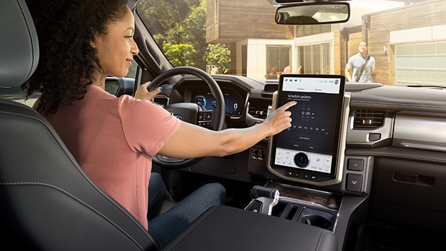 A Ford owner has parked their Ford vehicle in the driveway and is scheduling a software update on the in-vehicle touchscreen.