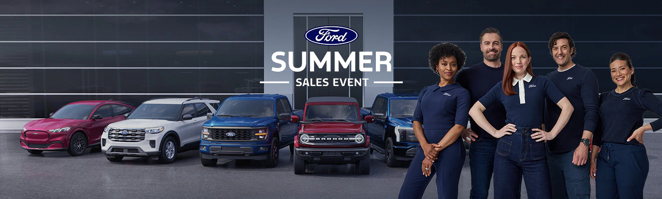 A Ford dealership with vehicles and the crew supporting the Ford For America Summer Sales Event.