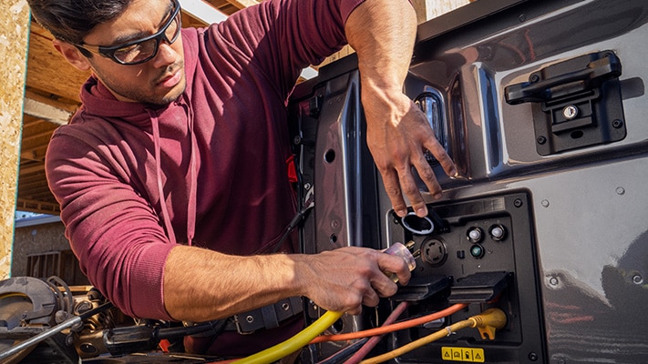 An F-150® Lightning® owner gets to work using the Pro Power Onboard™ outlets in the bed of their truck. 