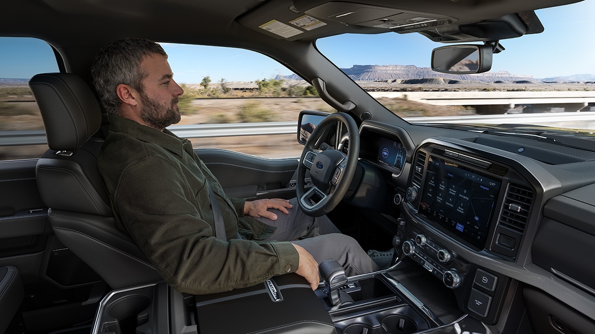 A driver sits back and relaxes while using BlueCruise on a divided highway.
