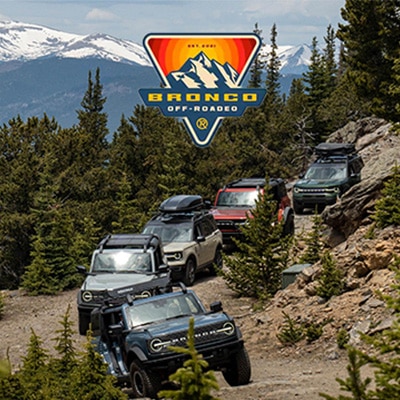 A line of Bronco Sport® SUVs take a bend on a mountain trail