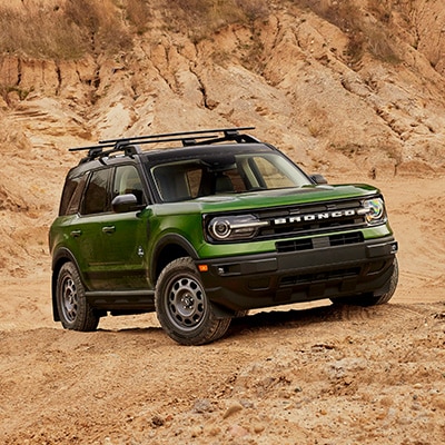 The Bronco Sport® SUV sits boldly on top of a trail hill.