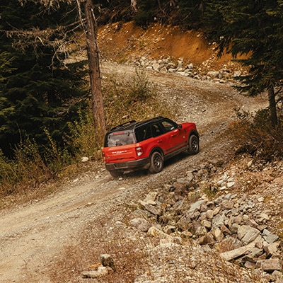 The Bronco Sport® SUV climbs a loose gravel strewn track.