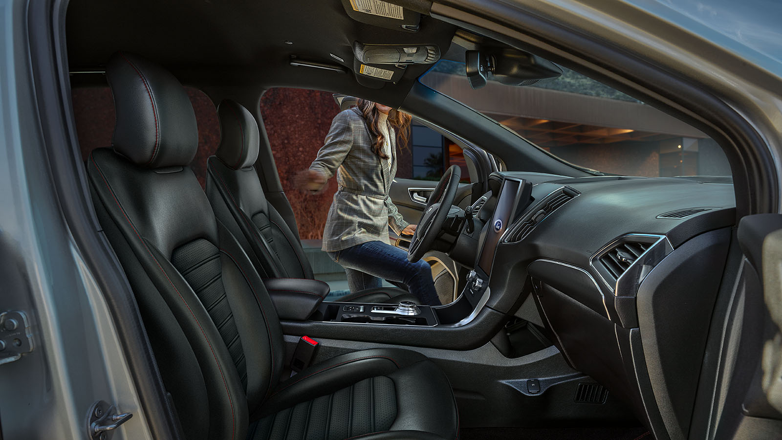 View of a driver getting into a 2023 Ford Edge® SUV with optional equipment shown in its interior.