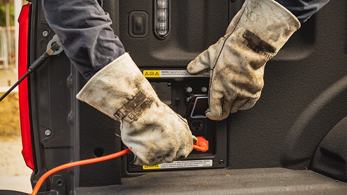 Close-up of a person in work gloves plugging in to the available Pro Power Onboard.
