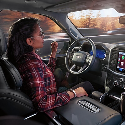 A driver in a 2023 Ford F-150® Limited truck actively using the available BlueCruise hands-free feature on the highway.