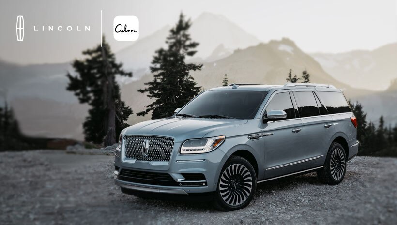 A Lincoln vehicle is parked in a mountainous area