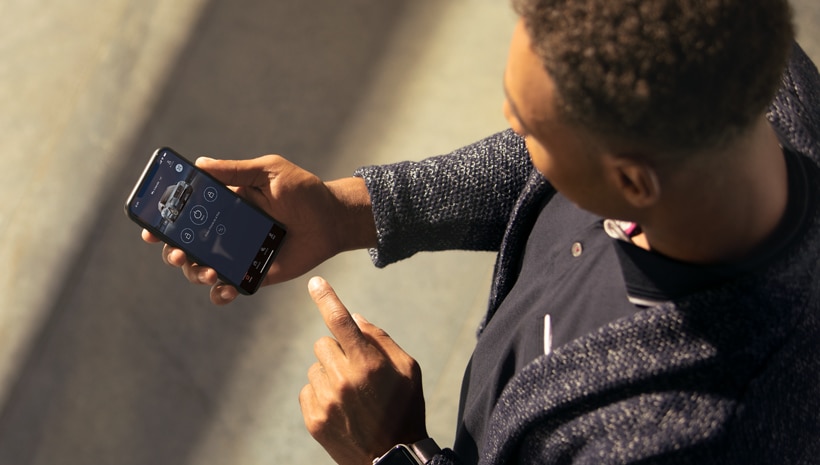 A person holding a smartphone is viewing the Lincoln Way App.
