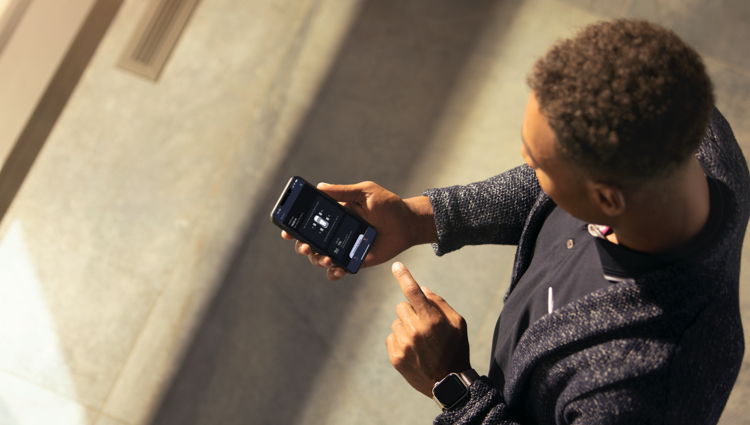 Una persona sosteniendo un smartphone mira la aplicación Lincoln Way.