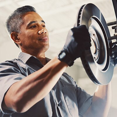 Lincoln technician fits brakes to a Lincoln vehicle.