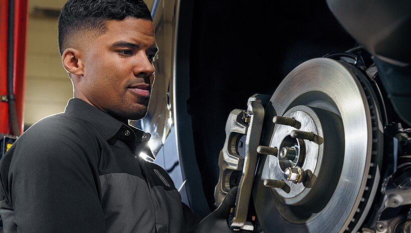 Technician with brake on vehicle