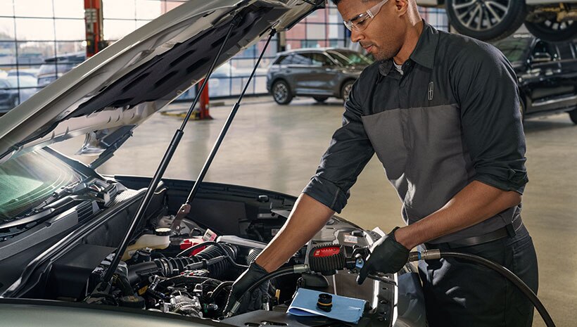 Lincoln technician changing vehicle oil