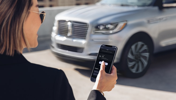 Una persona sostiene un teléfono con la aplicación Lincoln Way™.