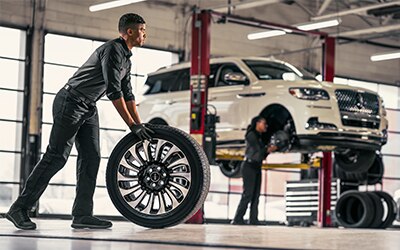 Service Technician rolling a tire