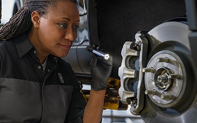 Service technician pouring oil into a vehicle
