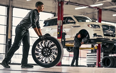 Service technician rolling a tire