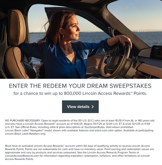 A person is looking out the window of a Lincoln vehicle.