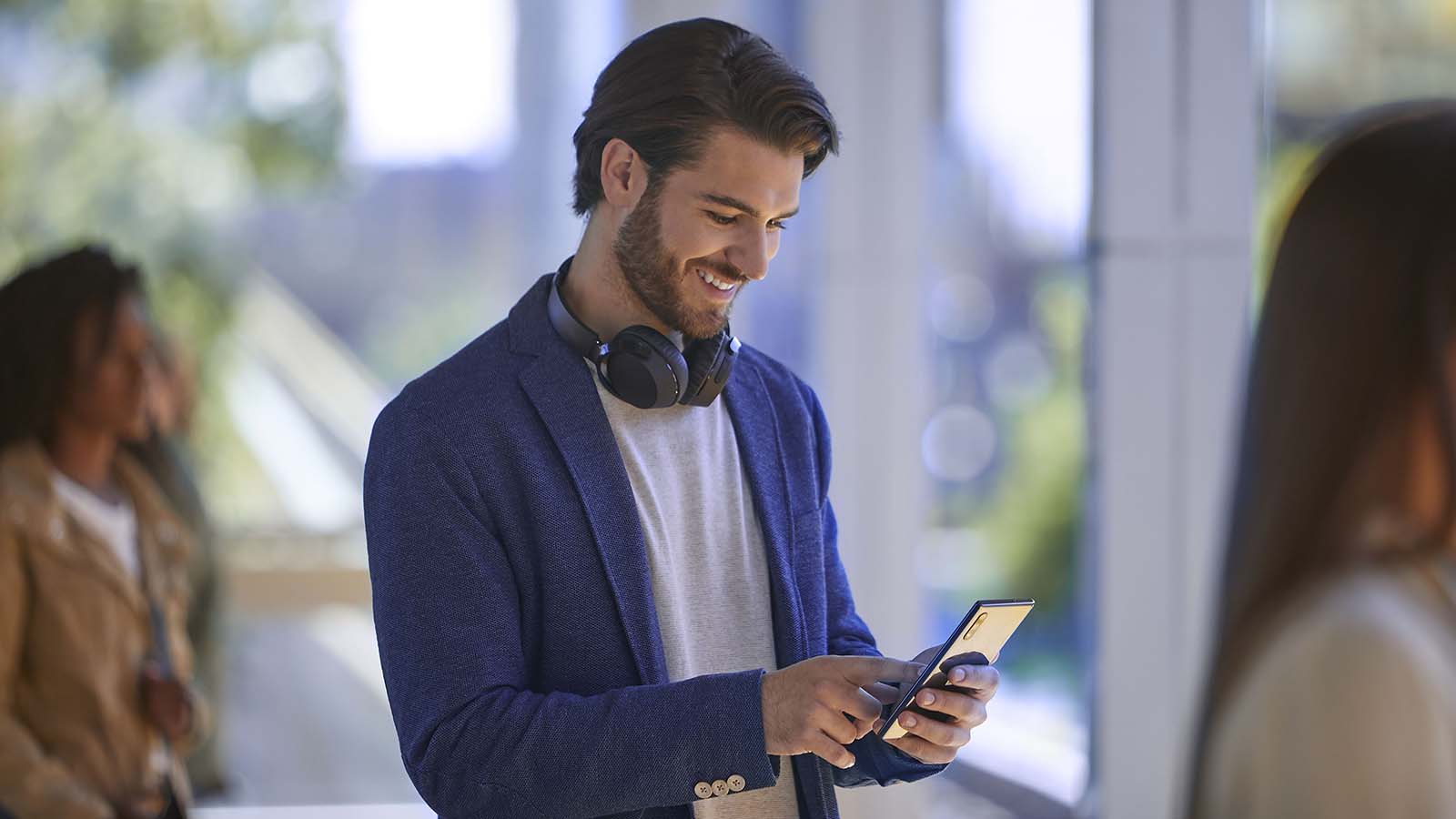 A man is shown holding a smartphone.
