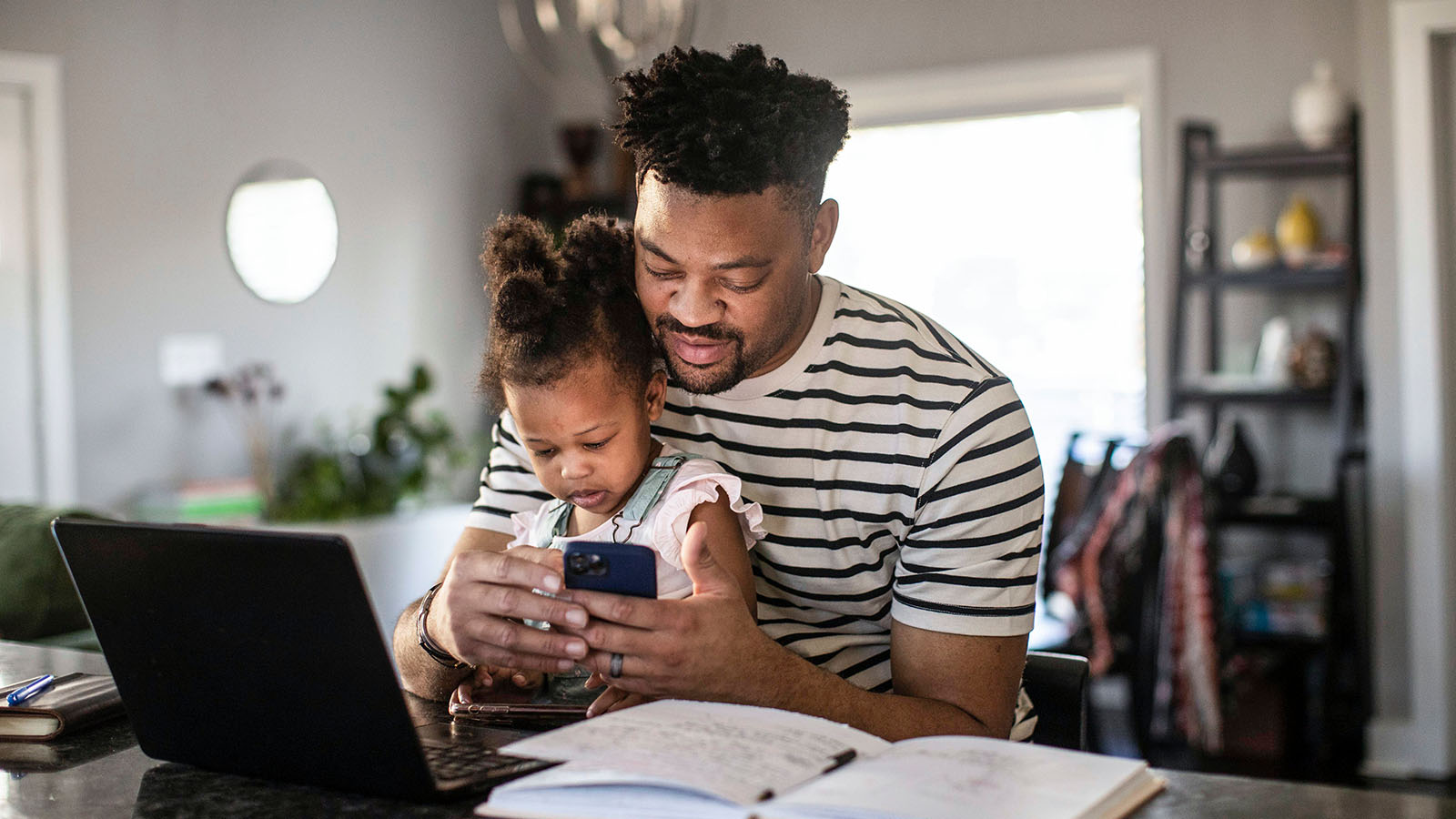 An owner checks FordPass on their phone while at home with their child.