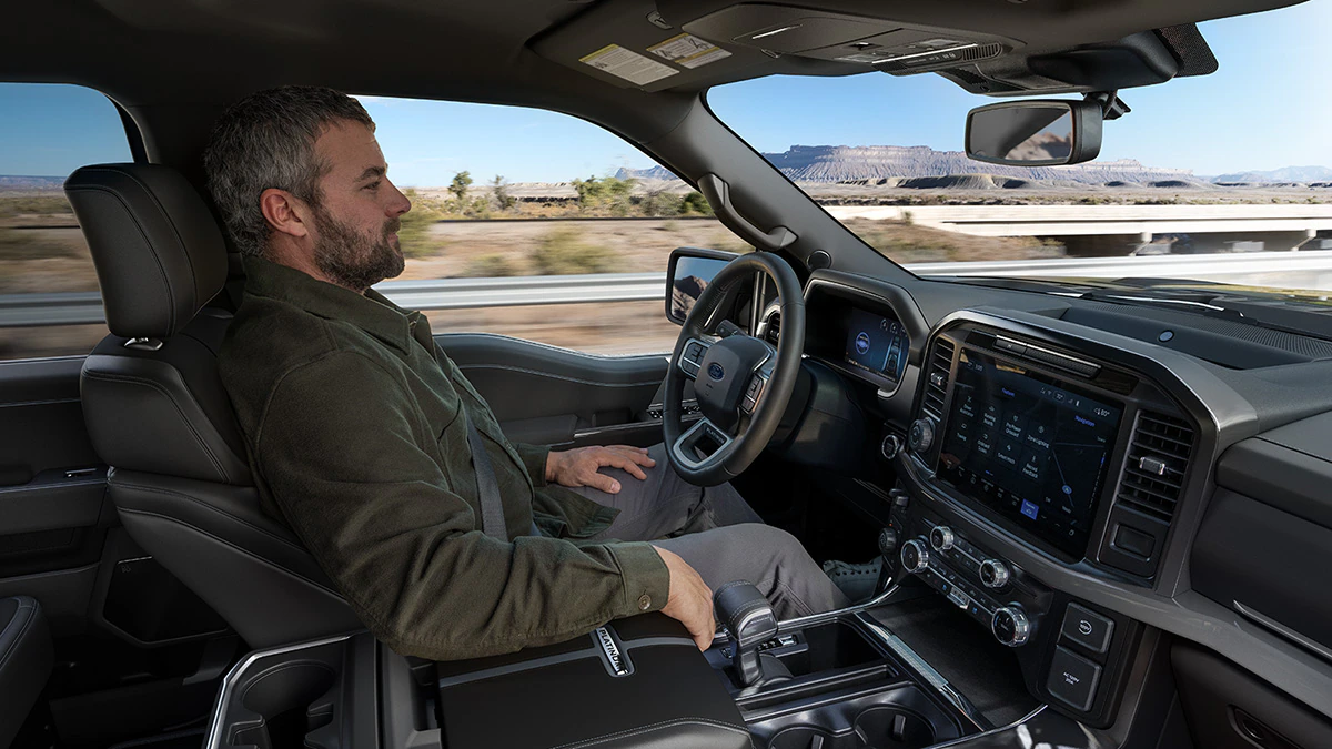 A driver sits back and relaxes while using BlueCruise on a divided highway.