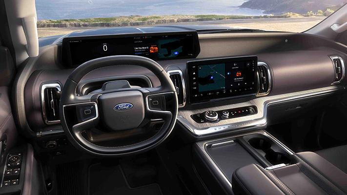 Through the windshield of the 2025 Expedition® SUV a waterfront extends to the horizon.