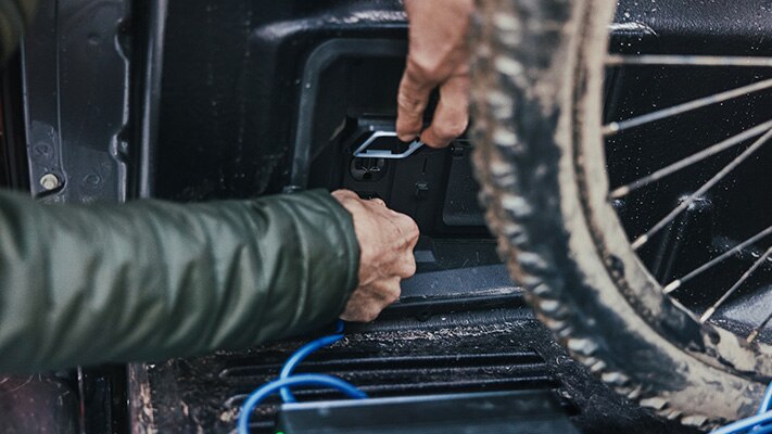 An F-150® Lightning® truck owner plugs into a Pro Power Onboard™ bed outlet.