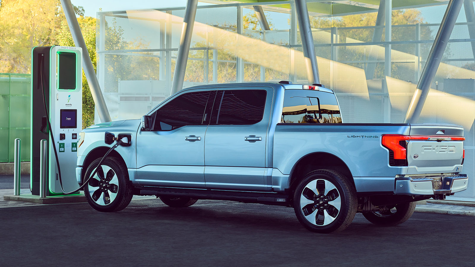 A Ford F-150 Lightning is at a charging station.