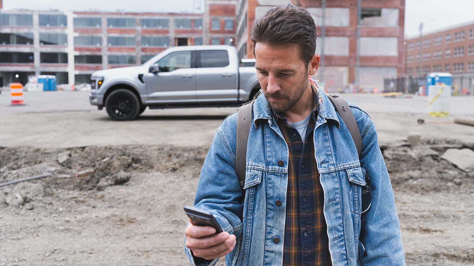 An owner checks FordPass on their phone at the worksite.