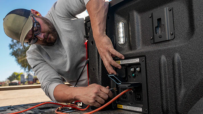 An F-150® truck owner plugs into a Pro Power Onboard™ bed outlet.